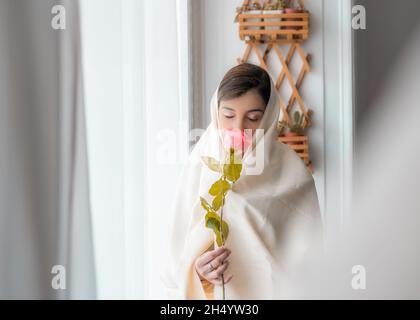 woman with haik takes a rose in hand Stock Photo