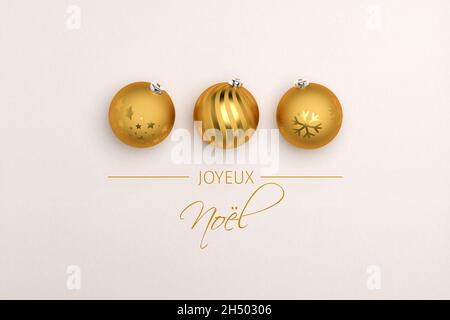 Three golden christmas baubles on paper background. French Message 'Joyeux Noël' (Merry Christmas) below. Stock Photo