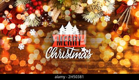 Christmas composition of spruce branches, gift, cinnamon, anise and confetti stars on rustic wooden background. Flat plan, top view Stock Photo