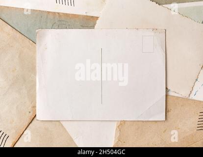 Vintage postcard on old grunge paper and envelopes background. Vintage background from old post cards. Stock Photo