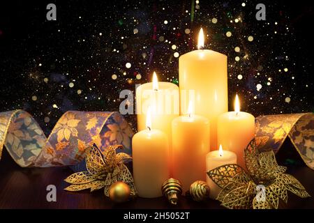 Christmas decoration with Christmas holiday candles and defocused lights. Christmas candles and ornaments over dark background with bokeh lights. Stock Photo