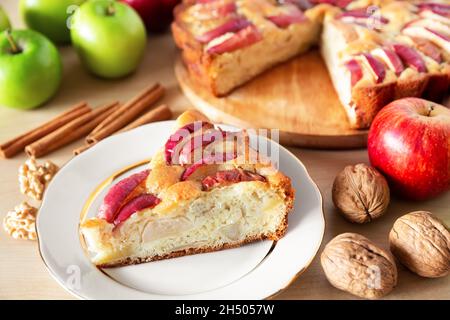 Piece of a tasty apple pie on a white plate, autumn baking concept. Homemade organic apple pie dessert ready to eat. Stock Photo