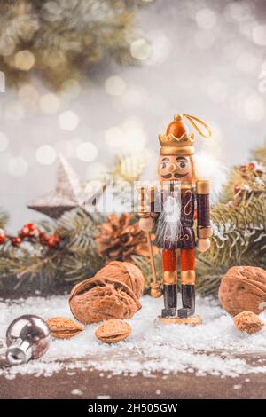 Christmas nutcracker toy soldier on Christmas background with fir tree branches, nuts, xmas balls. Christmas of New Year Greeting Card. Copy space. To Stock Photo