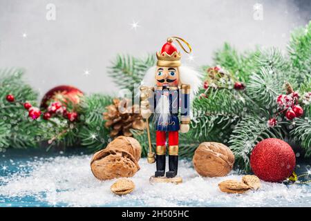 Christmas nutcracker toy soldier on Christmas background with fir tree branches, nuts, xmas balls. Christmas of New Year Greeting Card. Copy space Stock Photo