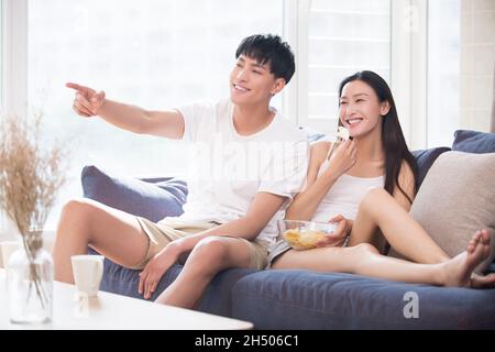 Happy young couple watching TV at home Stock Photo