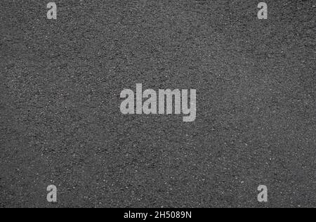 The texture of a smooth, wet, homogeneous asphalt. Side view. Stock Photo
