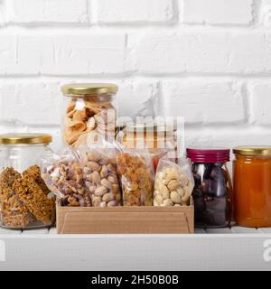 Set of long storage term mostly dry sweet energy foods on pantry shelf on brick wall background Stock Photo