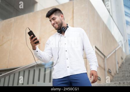 Young handsome hispanic man using smartphone outdoors. High quality photo Stock Photo