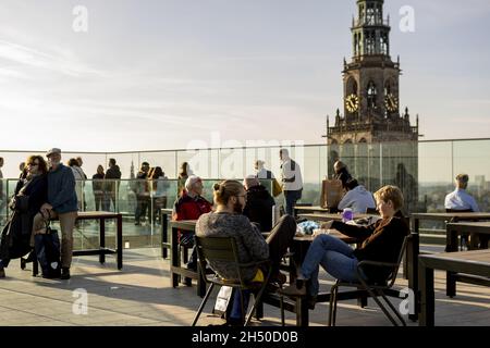 GRONINGEN, NETHERLANDS - Oct 09, 2021: People enjoying view and looking over cityscape of city from rooftop of Forum Groningen with the Martini church Stock Photo