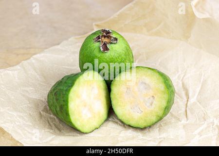 Fresh green feijoa (pineapple guava) fruit slices on light background in the kitchen. Stock Photo