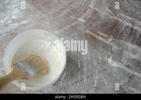 Homemade flour dough in bucket with brush on wooden tabletop. Preparing for making leavened-food or baking ingredients, pizza, bread, Youtiao, etc. Stock Photo