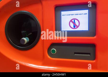 orange colored bottle return machine in a grocery store that shows in German: Not accepted or not empty Stock Photo
