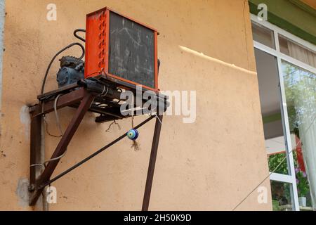 Orange homemade air conditioner with a large radiator and compressor on the wall of a house in the village of Esilova, Turkey. Cooling the room in hot Stock Photo