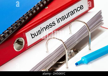 large red folder for business insurance documents including blue ring binder and blue maker Stock Photo