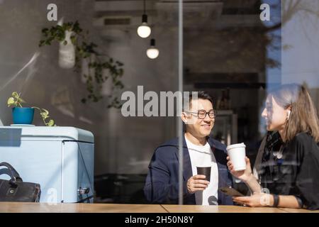 Multiracial couple drink coffee at table in cafe Stock Photo