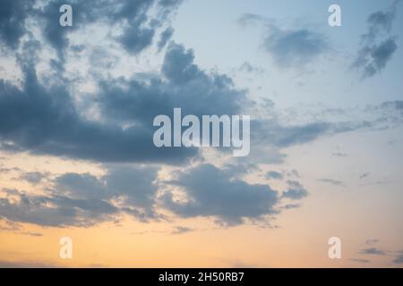 Fiery orange sunset sky and dramatic dark cumulus clouds, evening sky. Beautiful perfect sky for your photos. Heavenly background to overlay Stock Photo