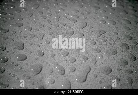Closeup of water droplets on the tabletop after the rain in dark gray tone Stock Photo
