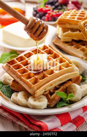 Belgian waffles served with butter banana mint leaf and syrup Stock Photo
