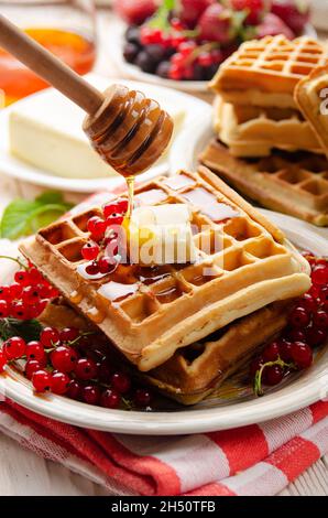Belgian waffles served with butter red currants and honey Stock Photo