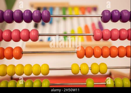 Bright colored hand abacus. Children's wooden toy for the study of arithmetic. Stock Photo