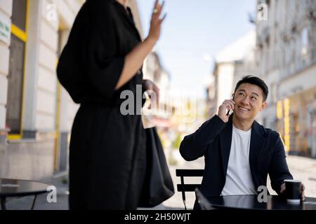 Man talking on smartphone and looking on woman Stock Photo