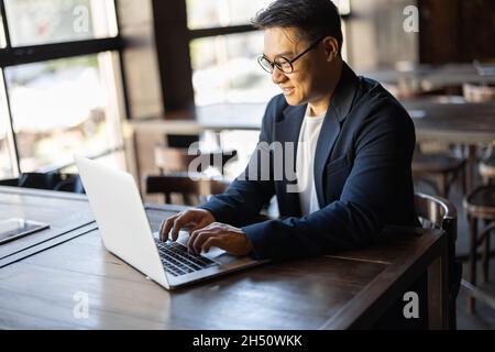 Businessman typing on laptop during work in cafe Stock Photo