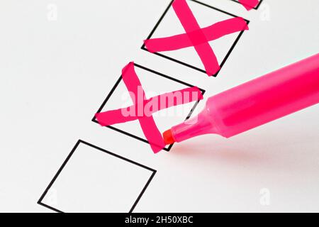 A base on which rectangular checkboxes are printed. A pink marker has ticked two boxes Stock Photo