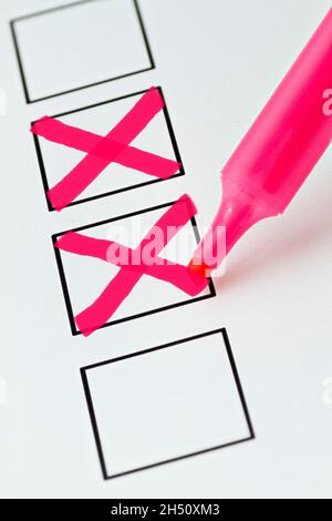 A base on which rectangular checkboxes are printed. A pink marker has ticked two boxes Stock Photo