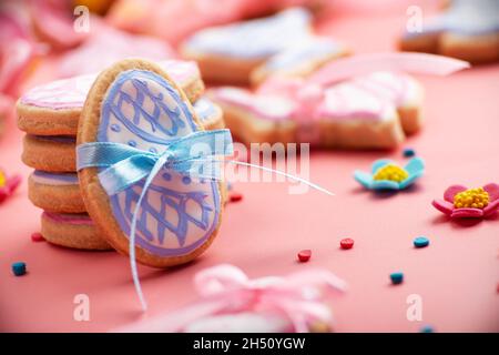 Easter baking background of frosted cookies in shape of egg on pink background Stock Photo