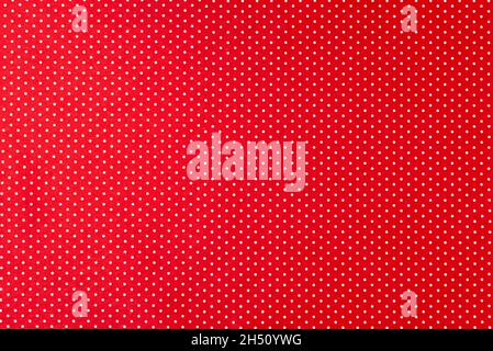 Background of red felt fabric with small white peas. Stock Photo