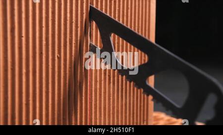 Building and constructions concept. Close-up of automatic saw cutting cutting the brick in the dark workshop. Stock Photo