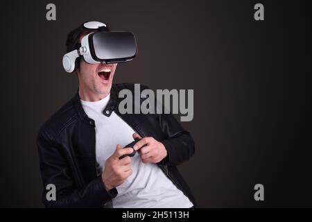 Man having fun dressed casual playing with virtual reality glasses with black isolated background Stock Photo