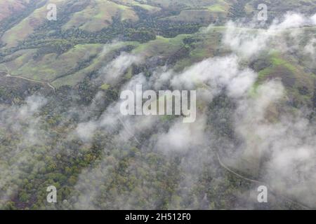 Low clouds drift across the rolling hills found east of San Francisco Bay, CA. This dry region turns green during the winter months due to rain. Stock Photo