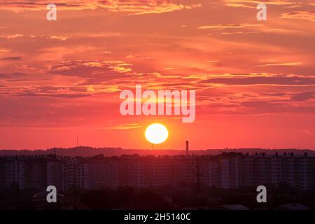Colorful evening landscape with soft pastel coloured cloudscape over dark distant cityscape with watercolor tinted sunset sky. Abstract nature backgro Stock Photo