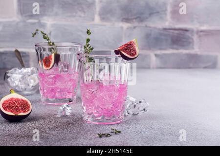 Autumn or winter pink fig cocktail with thyme and ice cubes. Selective focus Stock Photo