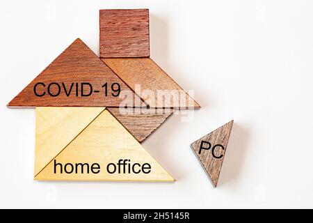 The missing building block with the Letters PC is inserted into a tangram house. The words CORVIT-19  and  home office are written on the Tangram ston Stock Photo
