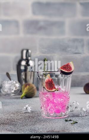 Autumn or winter pink fig cocktail with thyme and ice cubes. Selective focus Stock Photo