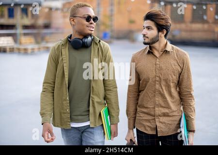 Male students walk and talk at university campus Stock Photo