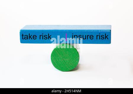 colored fragments in fragile balance with the words take risk | insure risk Stock Photo