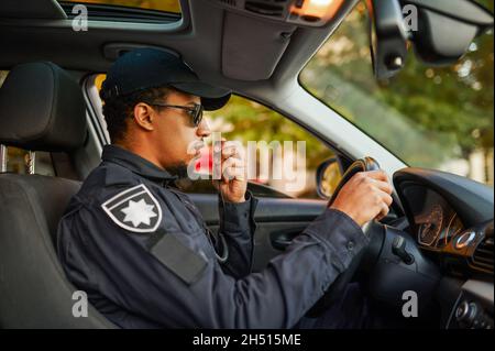 Male police officer talking on a walkie-talkie Stock Photo