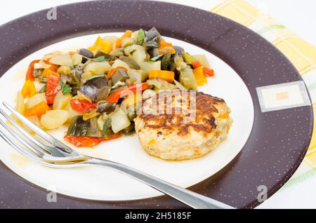 Stewed seasonal vegetables, homemade cutlet for dinner. Studio Photo Stock Photo