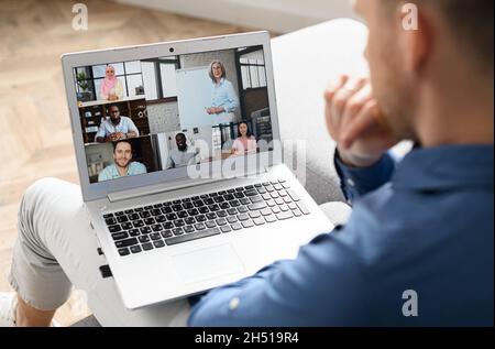 Group of diverse multiracial people on the laptop screen, a man is talking with colleagues, employees online. Video conference, brainstorm, webinar concept. E-studying Stock Photo