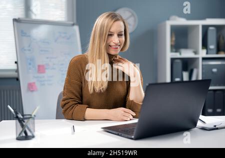 Happy woman working on laptop Stock Photo