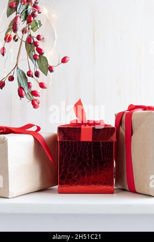 Christmas presents with red ribbon bows on a white background with border  of branch with red berries and white lights with copy space Stock Photo -  Alamy