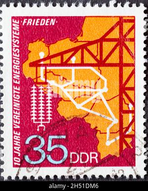 GERMANY, DDR - CIRCA 1973 : a postage stamp from Germany, GDR showing the energy network of the socialist countries, high voltage pylon. 10 years of U Stock Photo