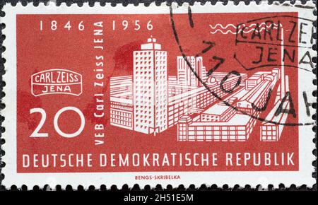 GERMANY, DDR - CIRCA 1956 : a postage stamp from Germany, GDR showing a historical picture of the building of the Carl Zeiss works, Zeiss symbol. 110 Stock Photo