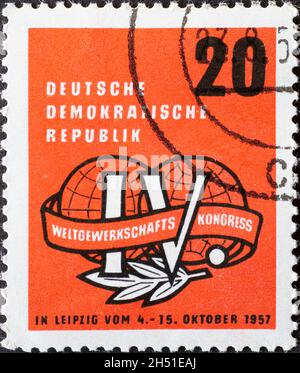 GERMANY, DDR - CIRCA 1957 : a postage stamp from Germany, GDR showing the emblem of the 4th World Trade Union Congress in Leipzig. Two stylized hemisp Stock Photo