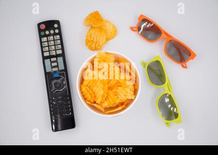 Potato chips for cinema. Watching movies with TV control, 3D glasses and snacks. Stock Photo