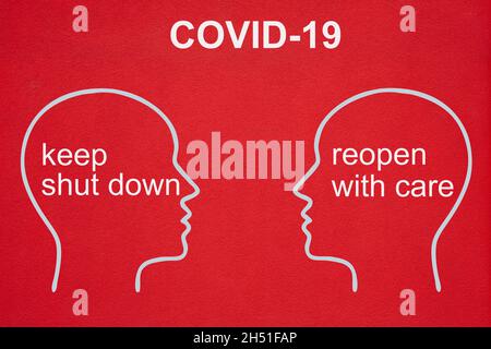 Two head outlines in white face each other. The text COVID-19 is written on top. In the heads the text: keep shut down and reopen with care. The backg Stock Photo