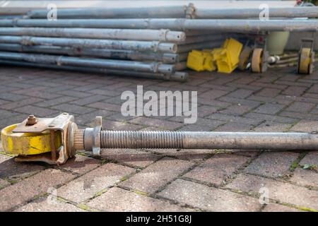 Pile of components of hired scaffolding or mobile platform work tower including adjustable leg and castor Stock Photo